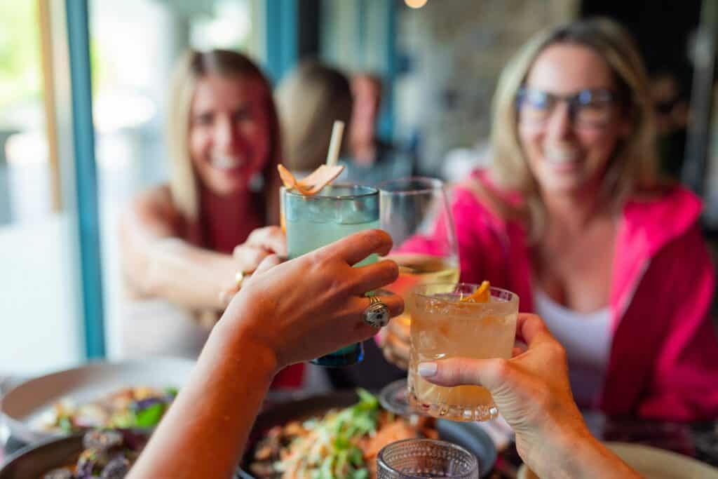 Ladies enjoying a happy hour drink together and having a cheers